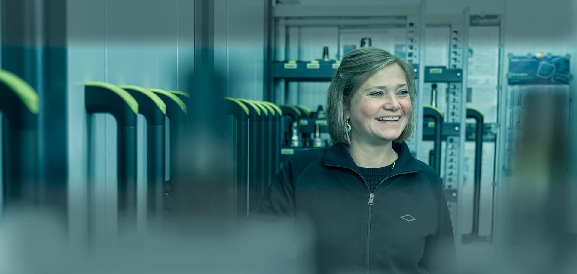 Eine Mitarbeiterin von GEDIA befindet sich an ihrem Arbeitsplatz und lacht.